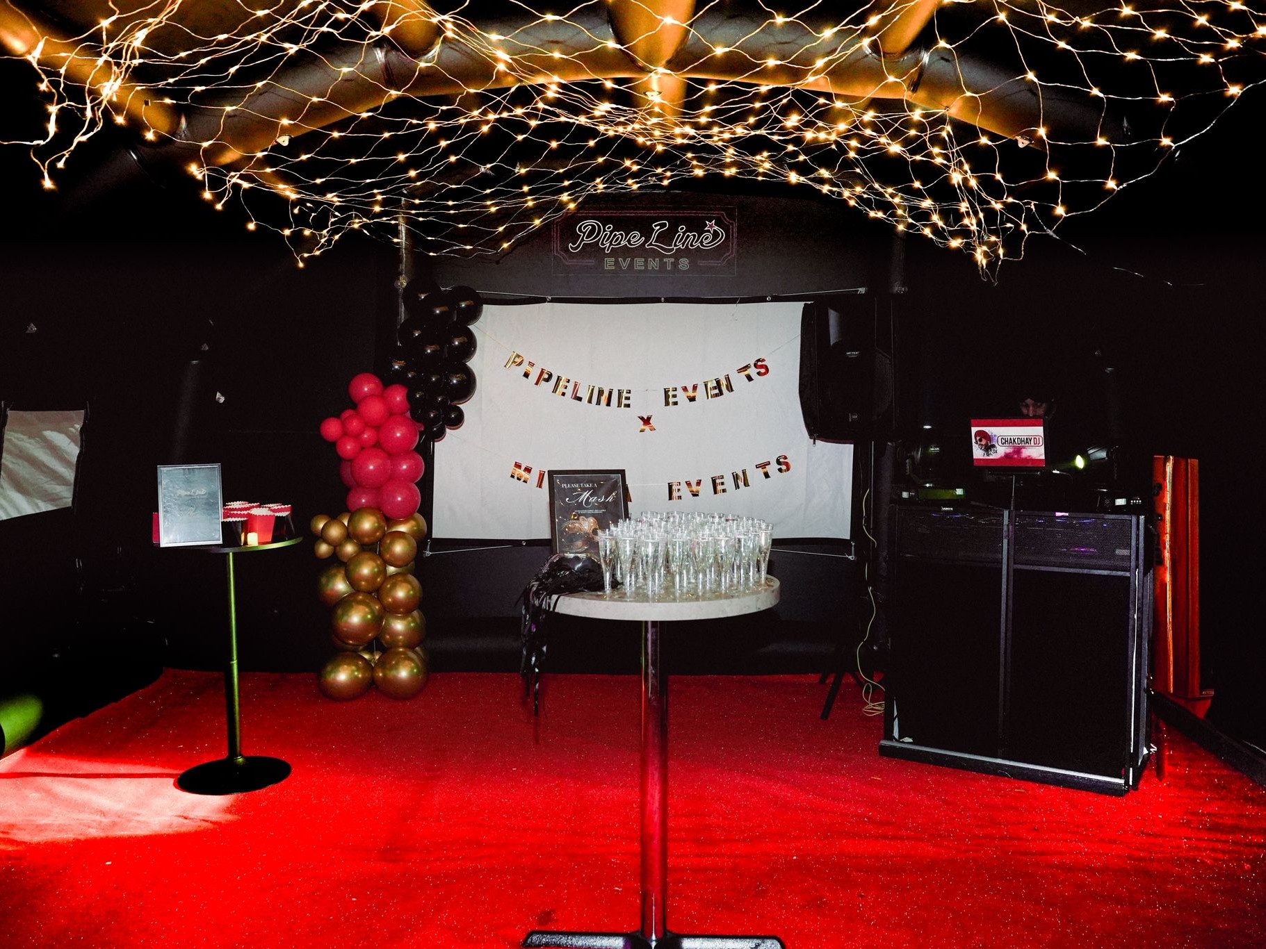 Inside the marquee with red carpet, DJ booth and welcome display