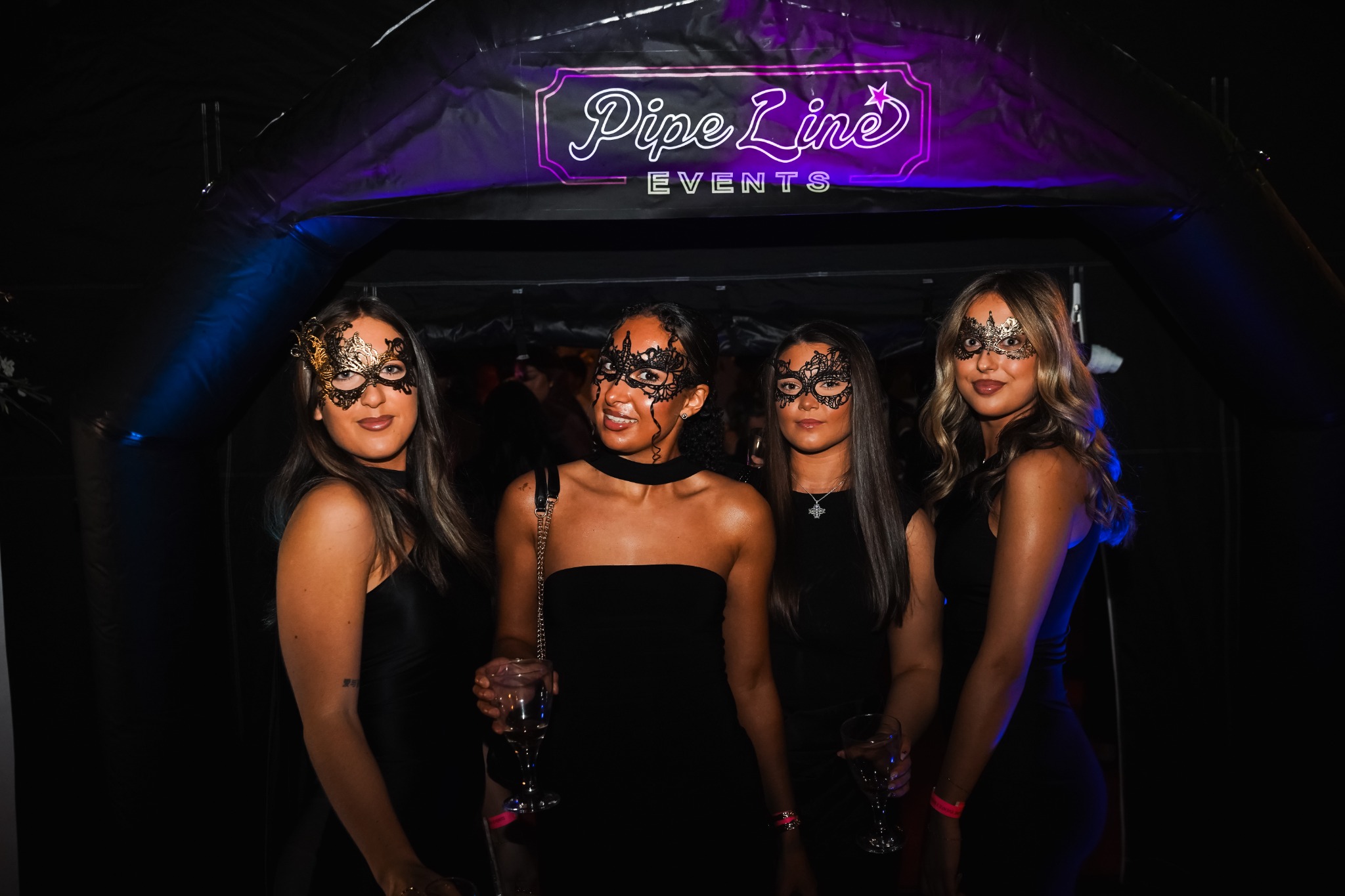 Guests at masquerade event under Pipeline Events bespoke events space entrance