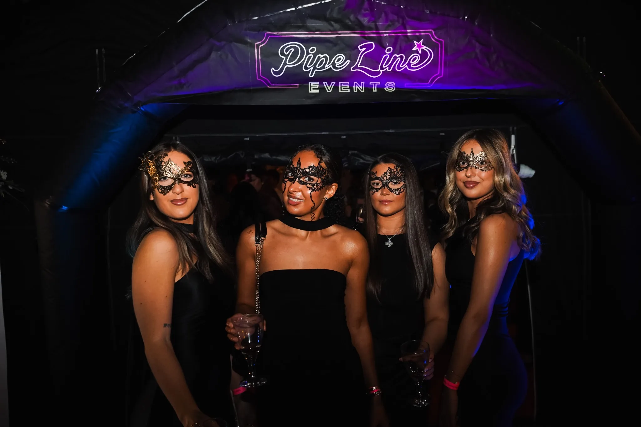 Guests at masquerade event under Pipeline Events marquee entrance