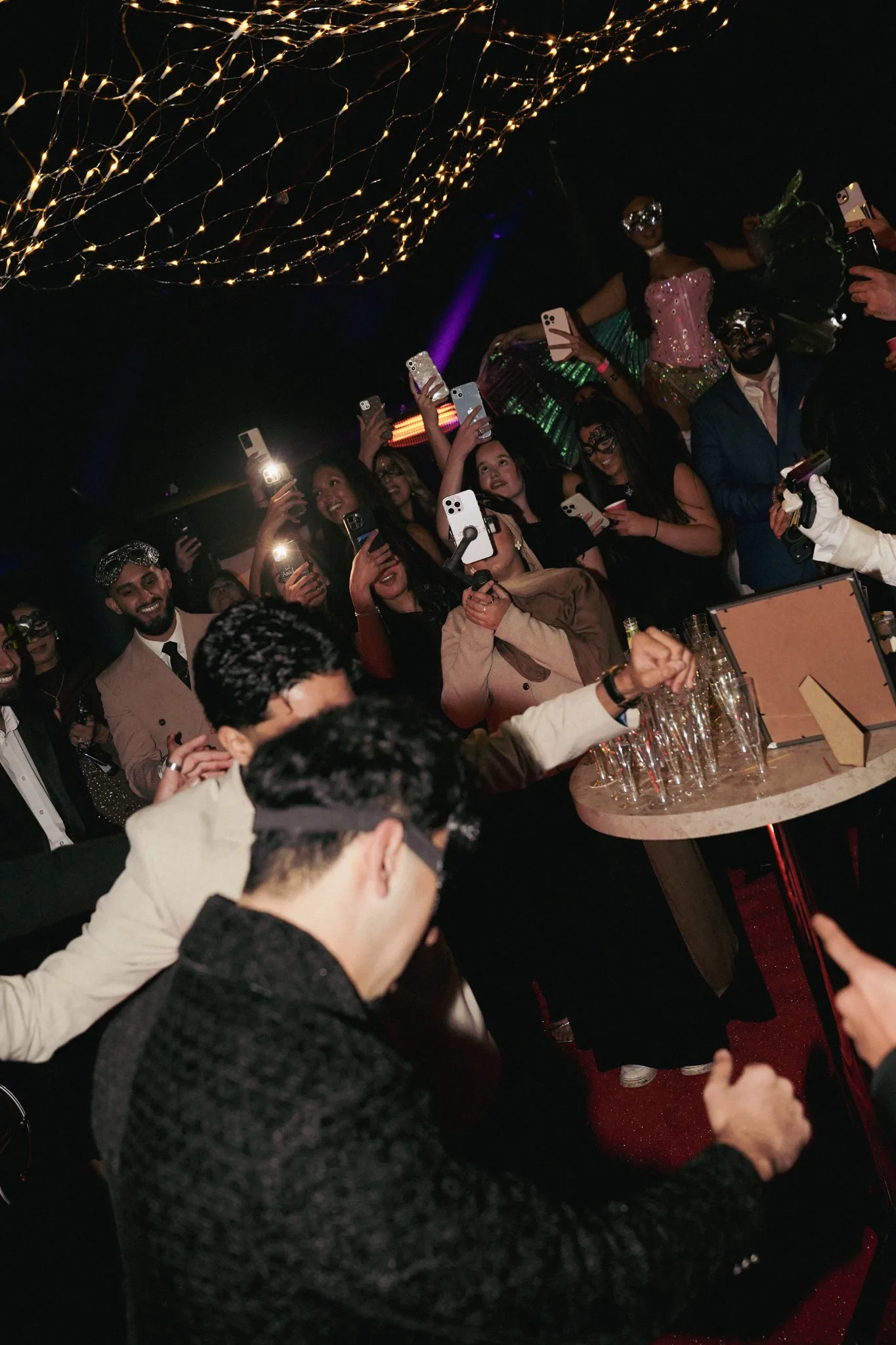 Crowd capturing entertainment inside the marquee on their phones