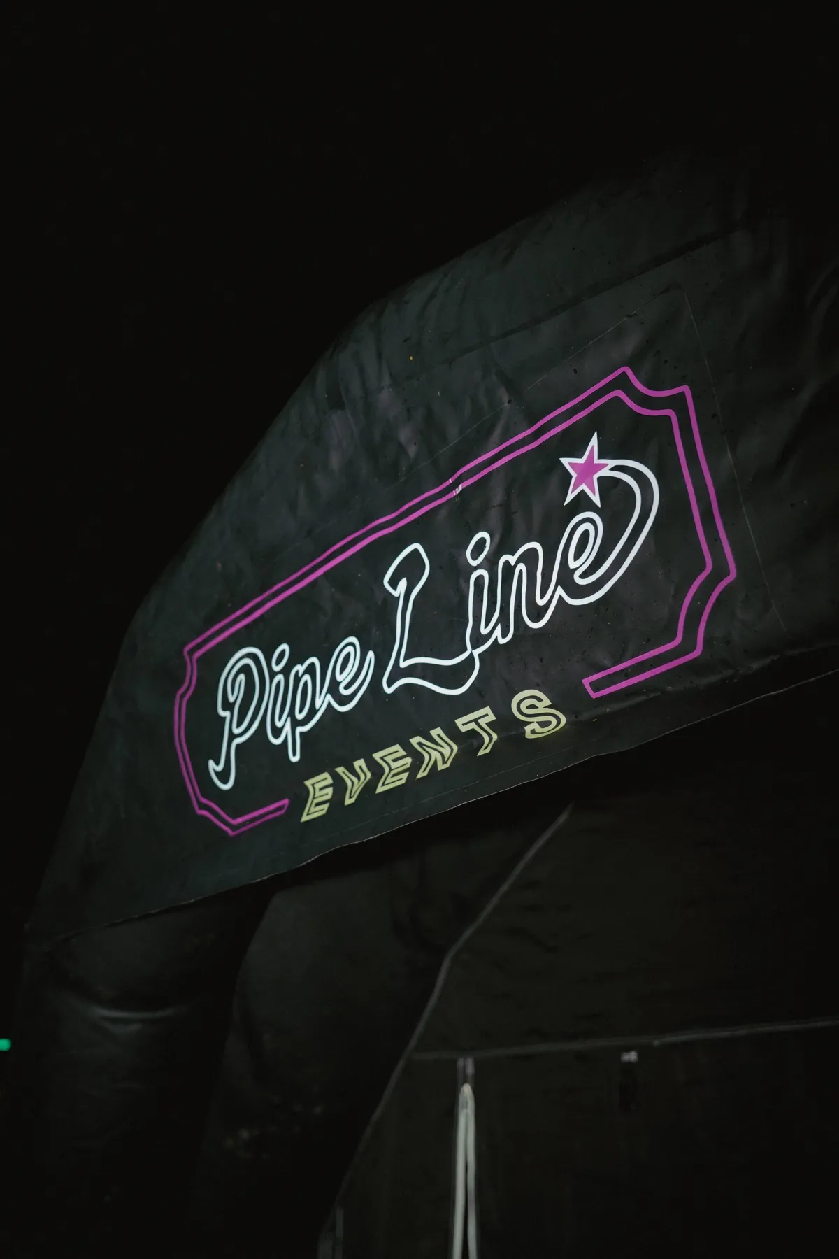 Pipeline Events logo on the Midnight Suite entrance arch at night